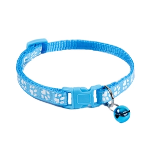 Close-up of light blue nylon pet collar with white paw prints and a blue metal bell