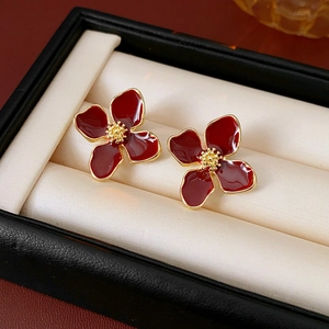 Close-up of vintage deep red flower earrings with gold edges in a luxury jewelry box