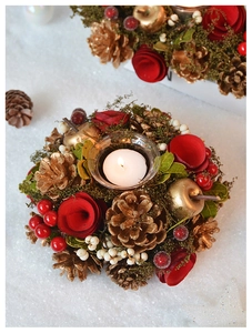 Detail of Christmas candle holder with red rose, gold pinecones and clear glass cup