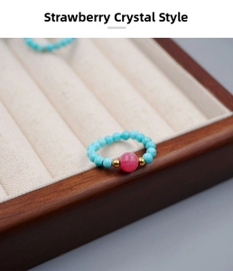 Detailed macro view of the turquoise beaded elastic ring with a pink strawberry quartz stone