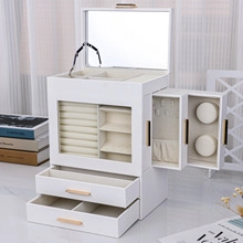 Detail view of white suede jewelry box with open drawers and side necklace hangers