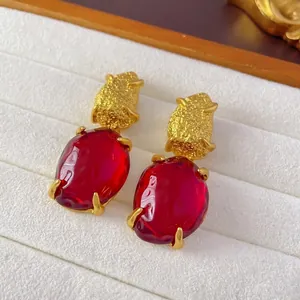 Vintage gold textured flower earrings with red gemstone and pearls in a white jewelry box