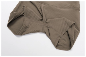 Close-up of dark coffee ribbed knit fabric with reinforced stitching on yoga shorts