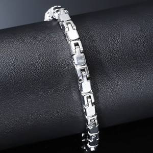 Sleek silver metal link bracelet displayed on a textured black leather cylinder stand