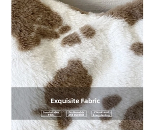 Macro shot of plush brown and white cow print faux fur fabric showing soft texture