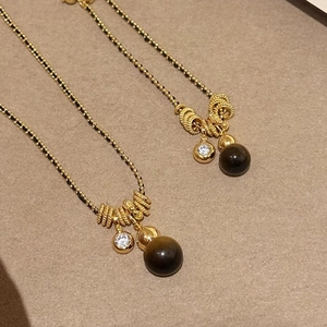 Gold plated tiger eye necklace with black beads and multilayered vintage style pendant