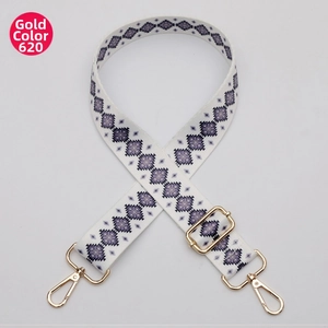 Detail of adjustable woven purse strap with purple geometric pattern and gold buckles