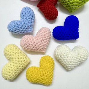 Top view of colorful handmade crochet heart pendants with detailed knit textures