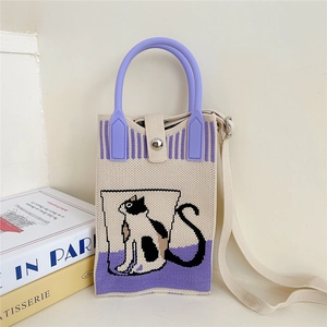 Detail of knitted cat mini bag showing purple handle and magnetic snap button closure