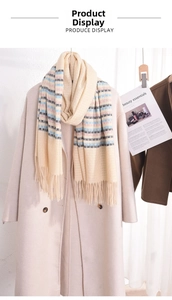 Detail of soft cream tassel scarf with pink blue stripes on long beige coat