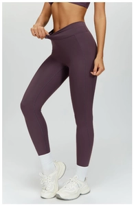 Detail of high waisted purple yoga pants with seamless stitching and matte fabric texture