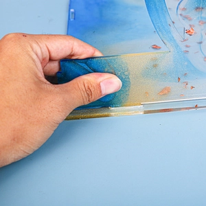 Close-up showing the flexibility of blue and gold glitter resin with metal foil flakes