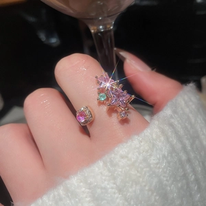 Macro view of adjustable rose gold ring featuring pink star zircons and green accents