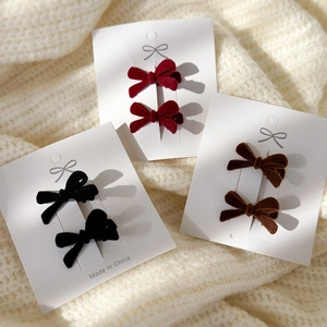 Velvet red black and brown bow hair clips set on a warm white knit sweater backdrop
