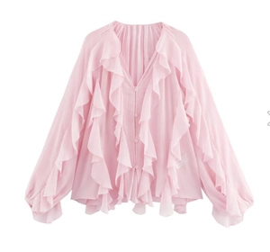 Detailed view of pink chiffon blouse featuring elegant ruffle trim and V-neckline buttons