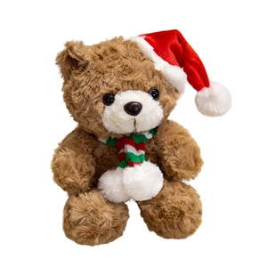 Brown teddy bear with red Christmas hat and striped scarf on white background