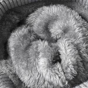 Winter knit hat with pom-pom and thick grey fleece lining for warmth and comfort