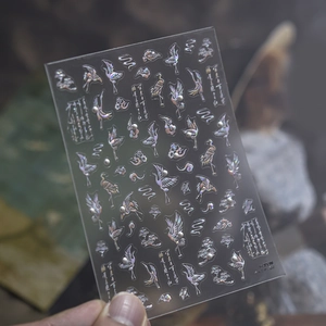 Detailed macro view of holographic nail art stickers with crane and cloud patterns