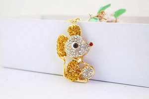 Detailed view of a gold mouse keychain with yellow and clear rhinestone embellishments