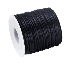 Roll of black braided cord for DIY jewelry making on white plastic spool spooling