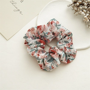 Close-up of floral print chiffon scrunchies on white stone tray with elegant decor