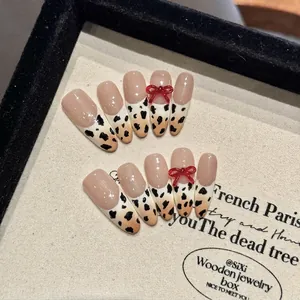 Handmade leopard print press-on nails with 3D red bows and French style cow pattern