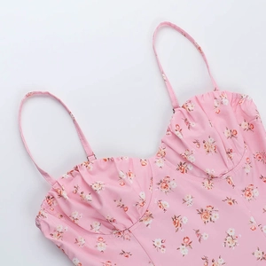 Détail de robe rose à fleurs avec fines bretelles et texture froncée sur la poitrine