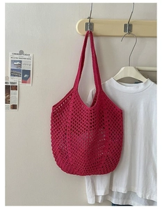 Detail of pink cotton woven tote bag with large hollow mesh texture on a wooden hook