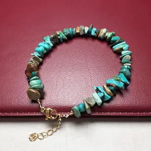 Macro detail of natural phoenix turquoise stone bracelet with golden lobster clasp closure