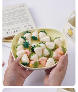 Detailed view of realistic PVC white and pink strawberries with leaf textures on a tray