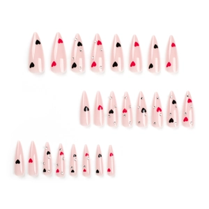 Pink stiletto press-on nails with heart patterns and rhinestones on a white background