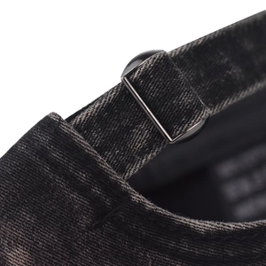 Detail of the metal adjustable buckle and washed denim texture on a baseball cap