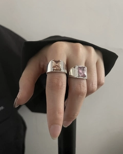 Detail of silver rings featuring large emerald-cut champagne and pink zircon stones