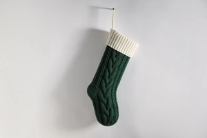 Detailed knit texture of green Christmas stocking with white cuff and hanging loop