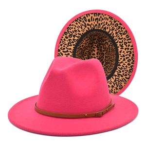 Detail of rose red fedora hat featuring leopard print lining and brown leather band buckle
