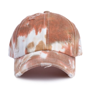 Dettaglio del cappello da baseball tie-dye con bordi usurati vintage e trama in tela