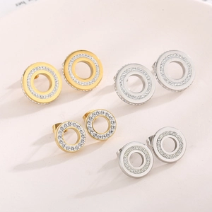 Detail view of gold and silver circular stud earrings with paved white zircons for women