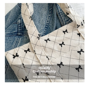 Close-up of quilted corduroy tote bag with black bow print and diamond stitching