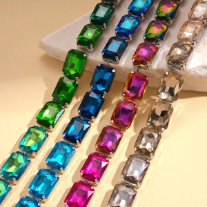 Close-up of geometric square rhinestone necklaces in green, blue, pink, and champagne gold