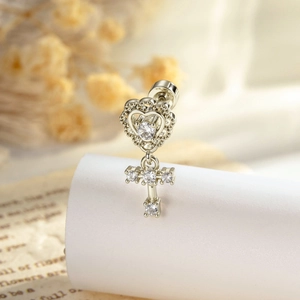 French vintage silver heart and cross stud earring with zircon on elegant background