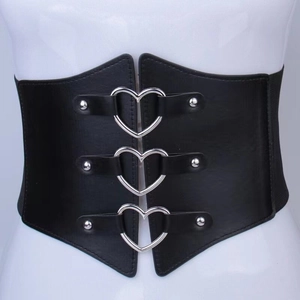 Détail d'une large ceinture élastique noire avec trois boucles cœur argentées et des rivets