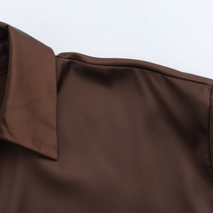 Gros plan du col et des coutures d'épaule d'une chemise à manches longues marron