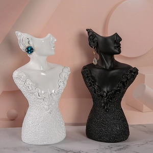 Detailed resin jewelry stand showing earring display on black and white bust statues