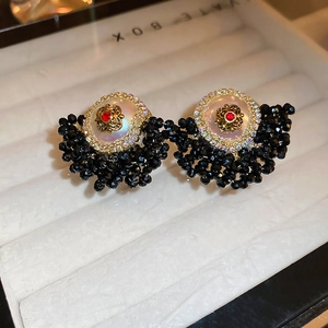 Detailed macro view of vintage crystal flower earrings with black faceted beads in a gift box