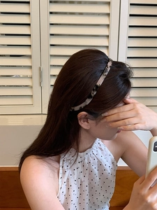 Close-up of leopard print acrylic headband worn by a model for a vintage look