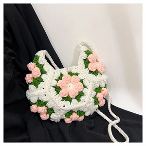 Close-up of handmade crochet bag with 3D pink flowers and elegant pearl clasp button