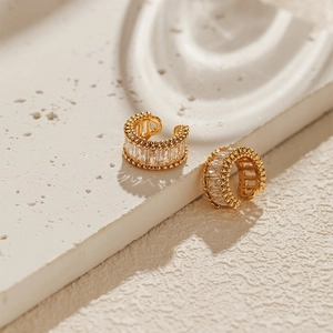 Detailed close-up of gold C-shaped ear cuffs with rectangular zircon stones