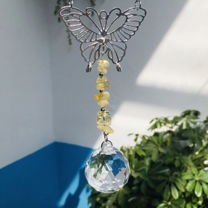 Close-up of hanging crystal suncatcher with silver butterfly and yellow stones