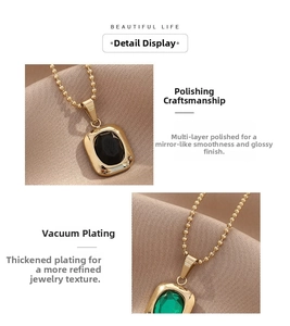 Detail of polished gold bezel pendants with emerald and black faceted gemstones
