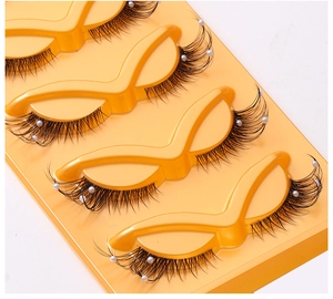 Close-up of 5 pairs of cat eye false eyelashes with white pearl beads on clear band